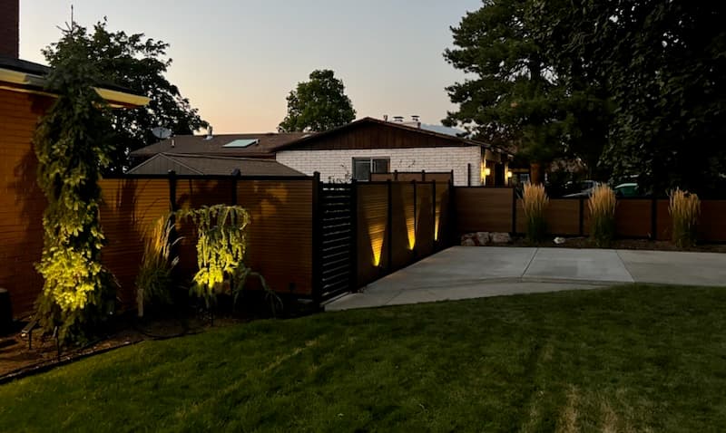 Fence and landscape lighting at dusk by SG Landscaping