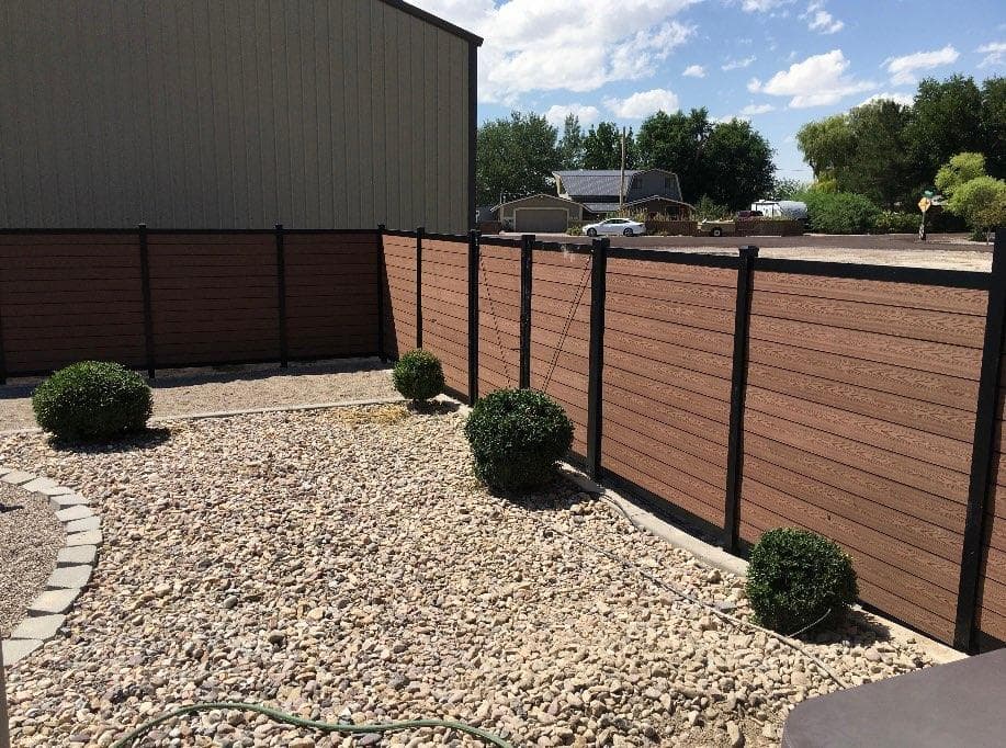 Backyard fence and river rock border by SG Landscaping