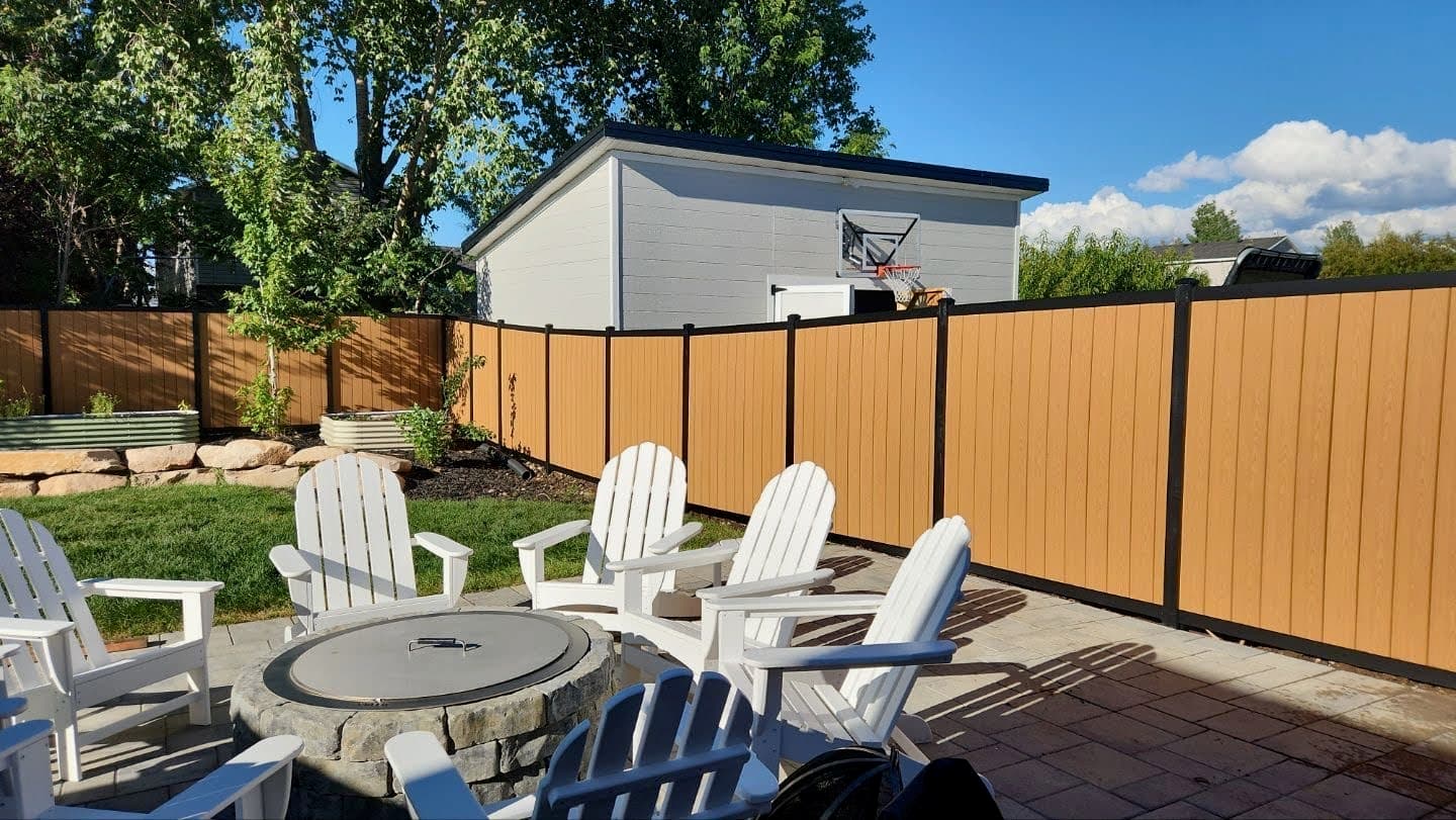Composite privacy fence with fire pit patio by SG Landscaping
