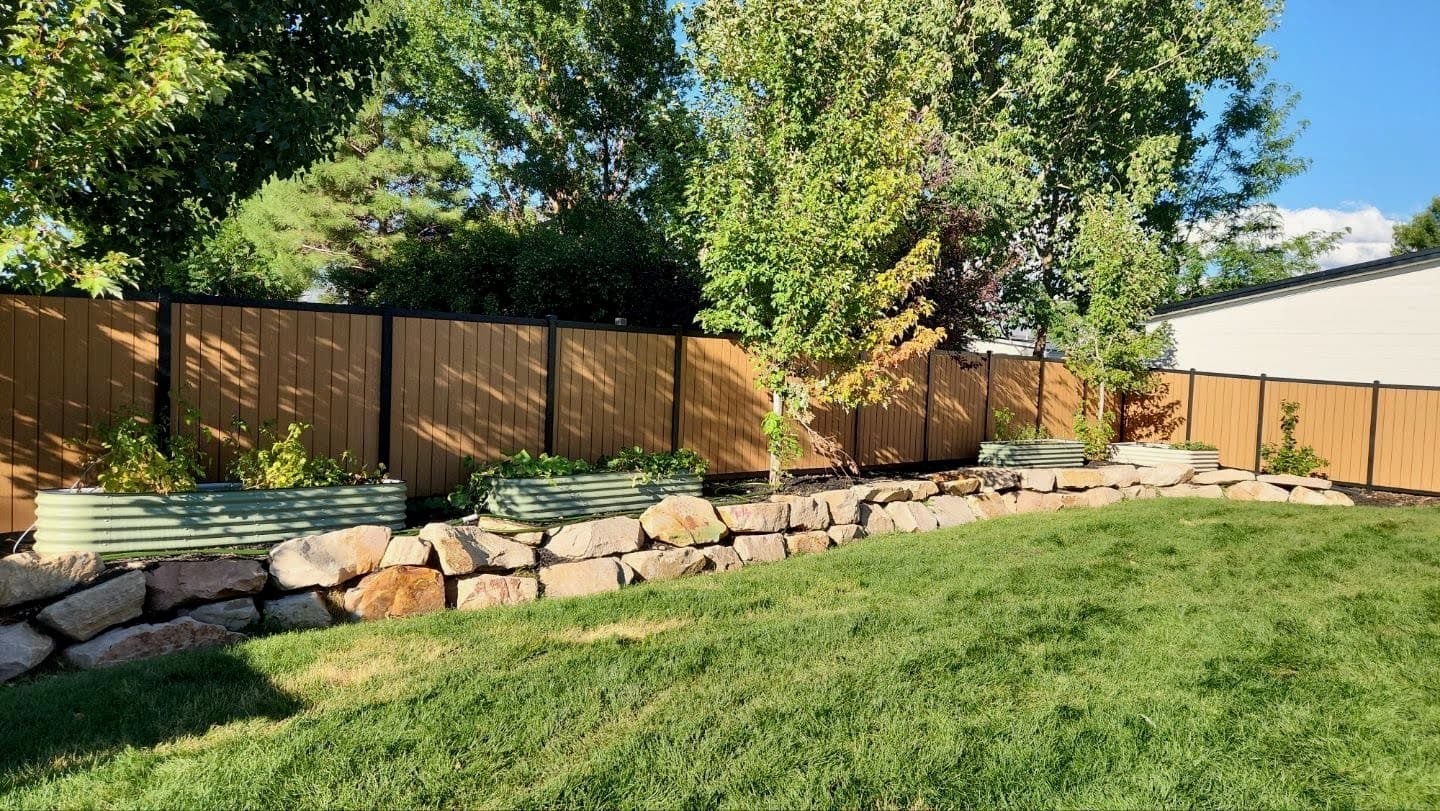 Raised garden beds and stone wall by SG Landscaping