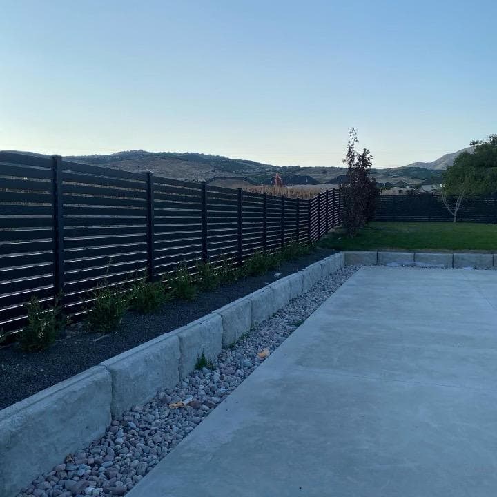 Patio, retaining wall, and slat fence by SG Landscaping